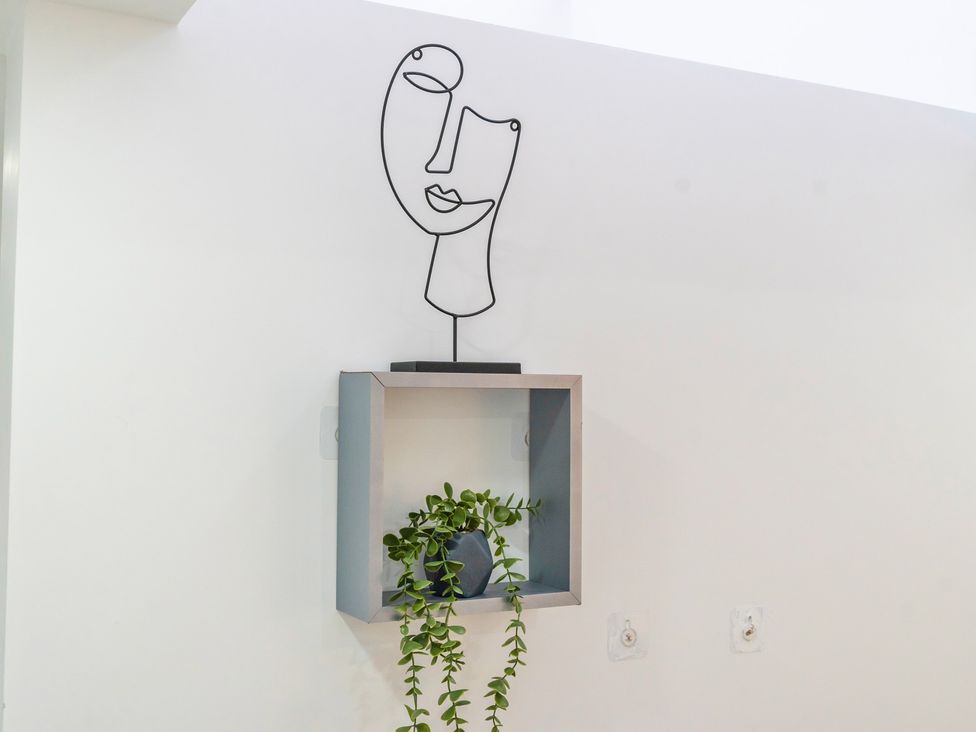 A wall shelf with a plant and an art sculpture at 5 Pump House in Birmingham