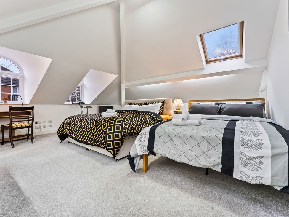 A bedroom with two beds and a table at 5 Pump House in Birmingham