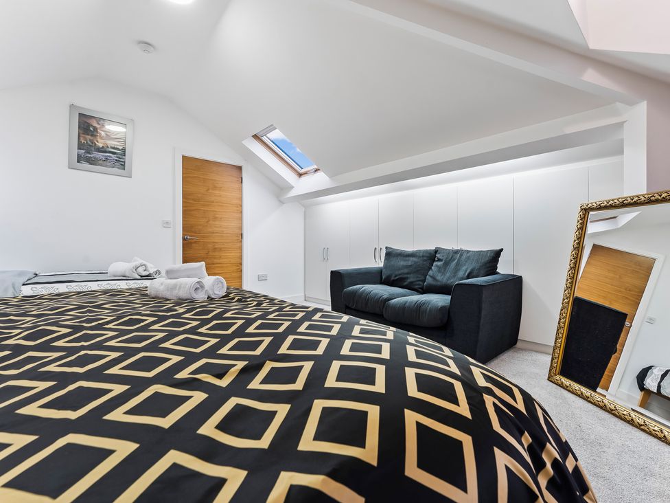 A bedroom with a bed and sofa at 5 Pump House in Birmingham