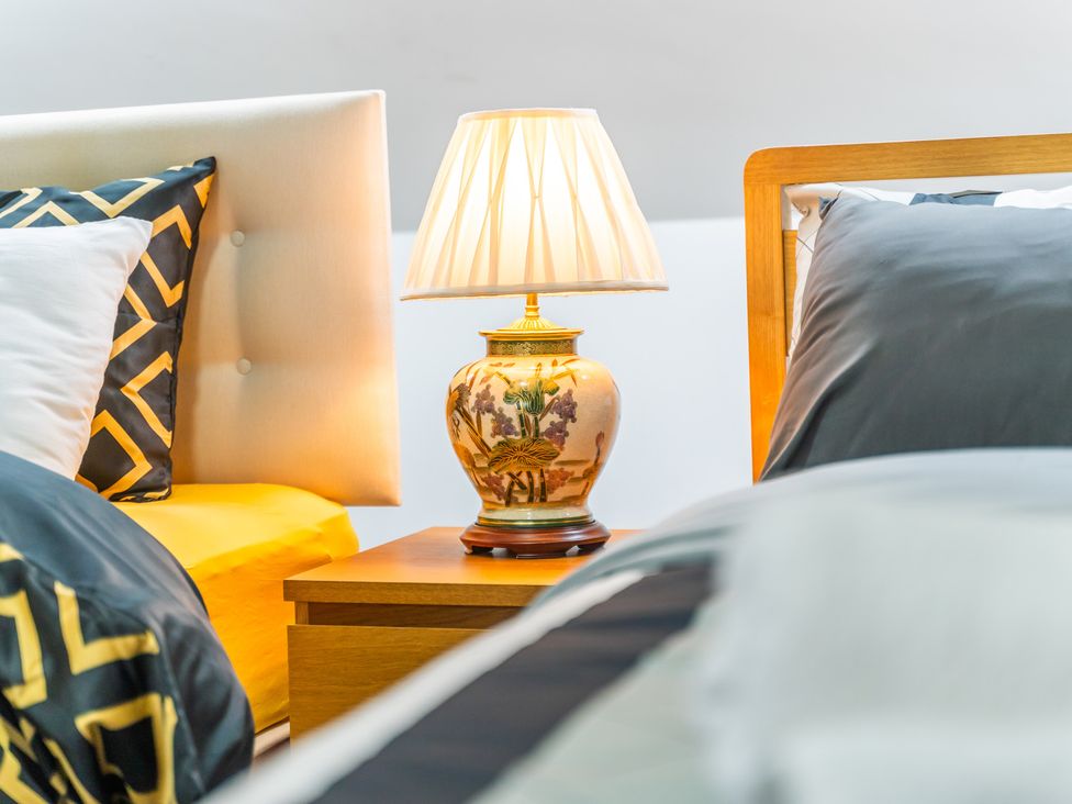 A bedroom with beds and a lamp on a nightstand at 5 Pump House Birmingham