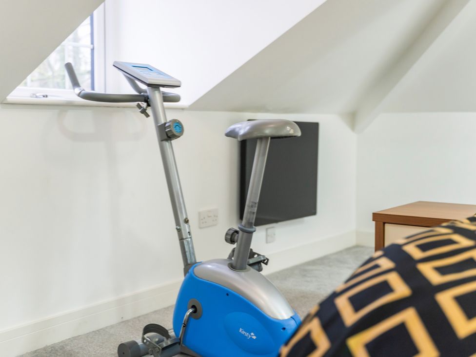 An exercise bike in a room with a window and radiator at 5 Pump House Birmingham