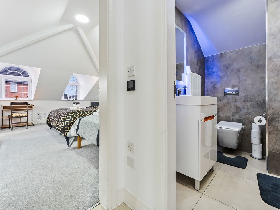 A bedroom with a bathroom visible at 5 Pump House in Birmingham