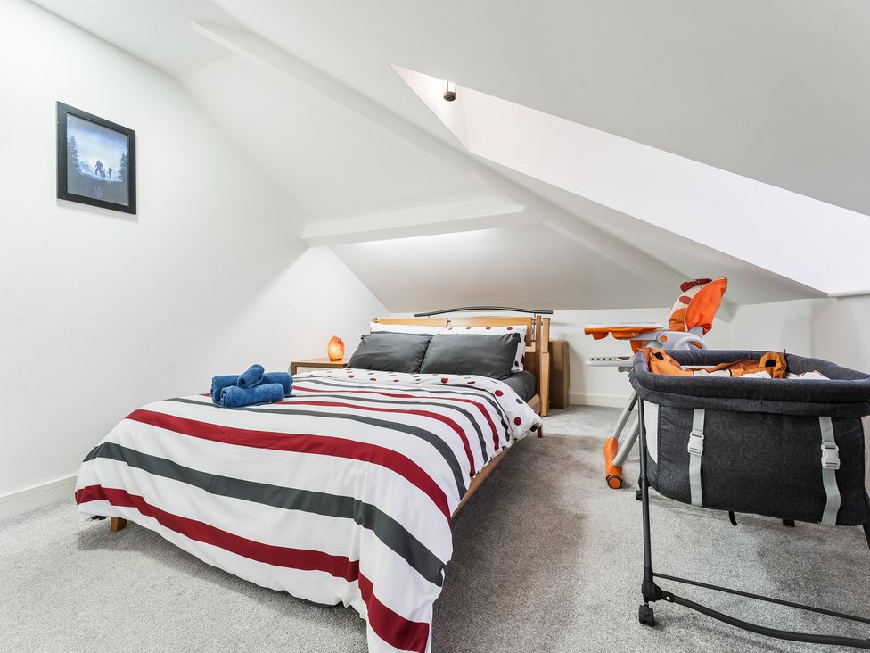 A bedroom with a bed and crib at 5 Pump House in Birmingham