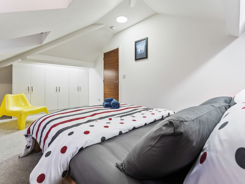 A bedroom with a bed and chair at 5 Pump House in Birmingham
