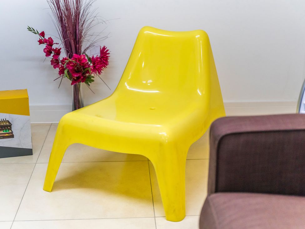 A yellow chair next to a flower arrangement and a box at 5 Pump House Birmingham