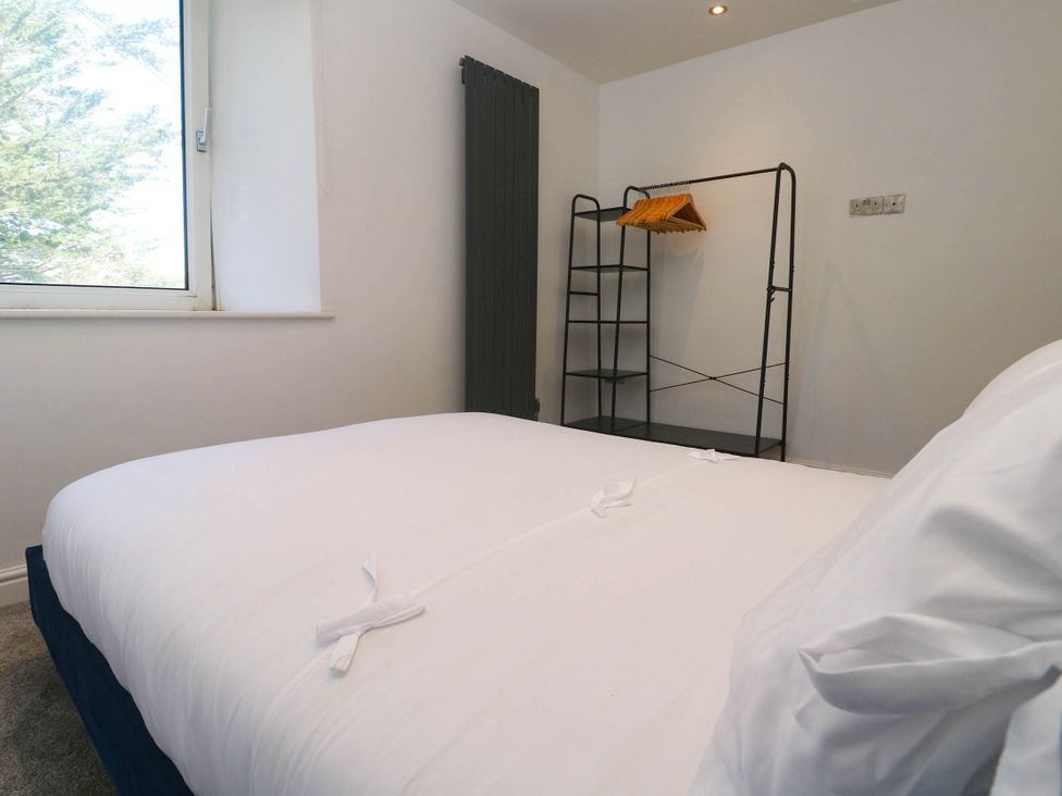 A bedroom with a bed and a clothing rack at The Lookout in Redruth