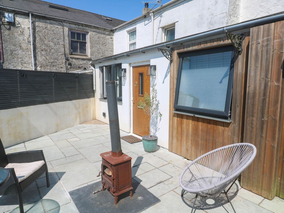 An outdoor area with a small stove and chairs at The Lookout in Redruth