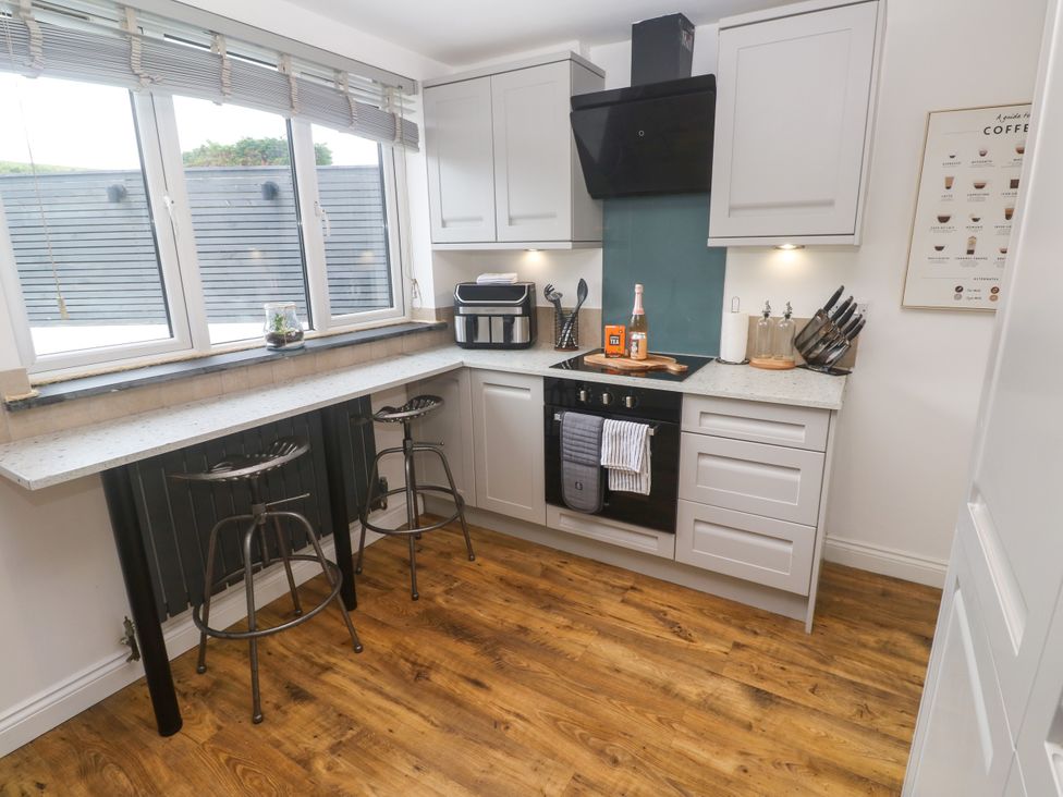 A kitchen with bar stools and modern appliances at The Lookout in Redruth
