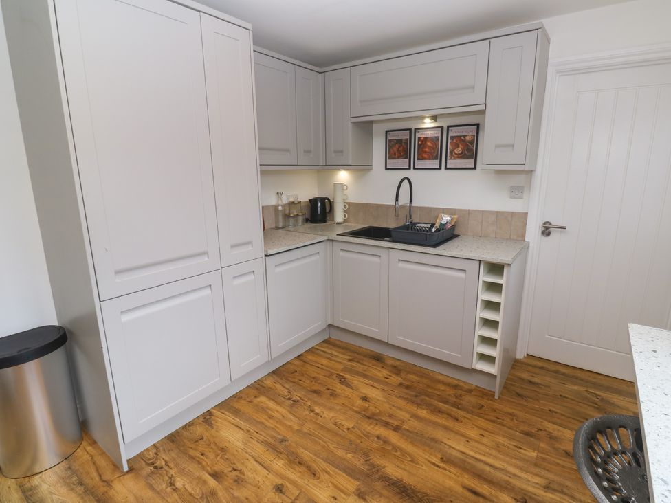 A kitchen with cabinets, sink, kettle, and countertop at The Lookout in Redruth