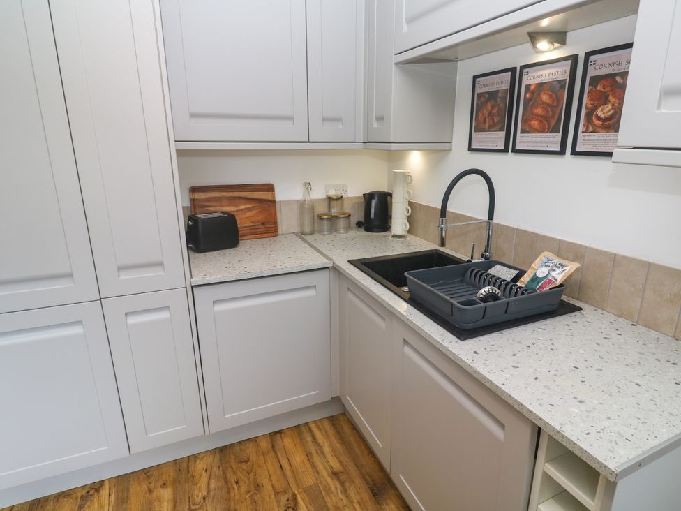 A kitchen with a sink, cutting board, and toaster at The Lookout in Redruth
