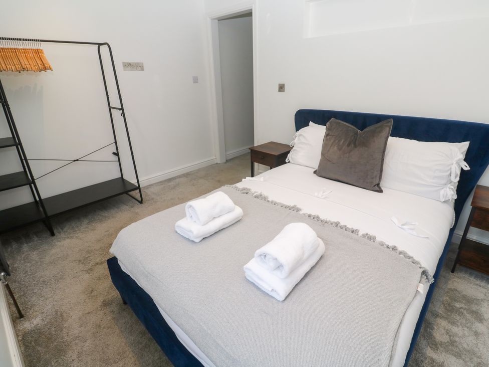 A bedroom with a bed and a hanger rack at The Lookout in Redruth