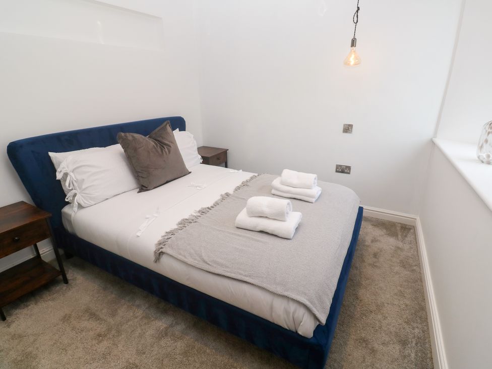 A bedroom with a bed and nightstands at The Lookout in Redruth