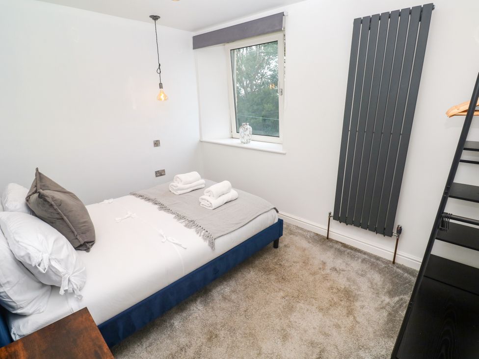 A bedroom with a bed and window at The Lookout Redruth