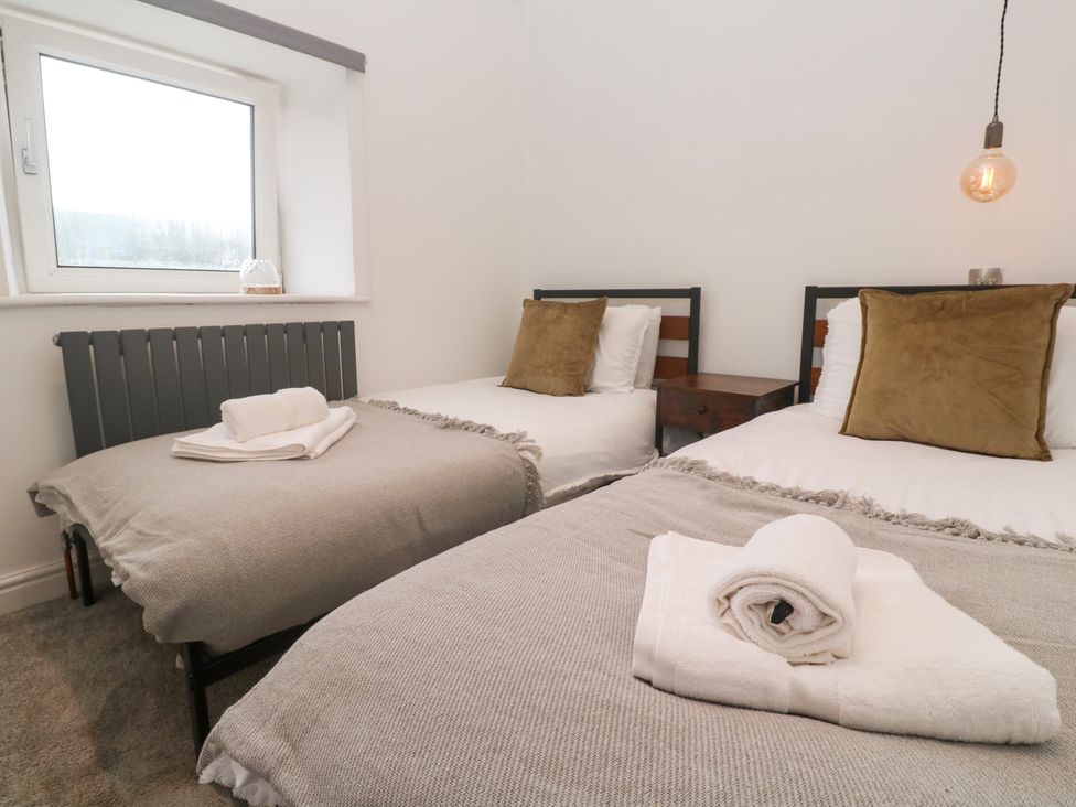 A bedroom with two beds and a window at The Lookout in Redruth