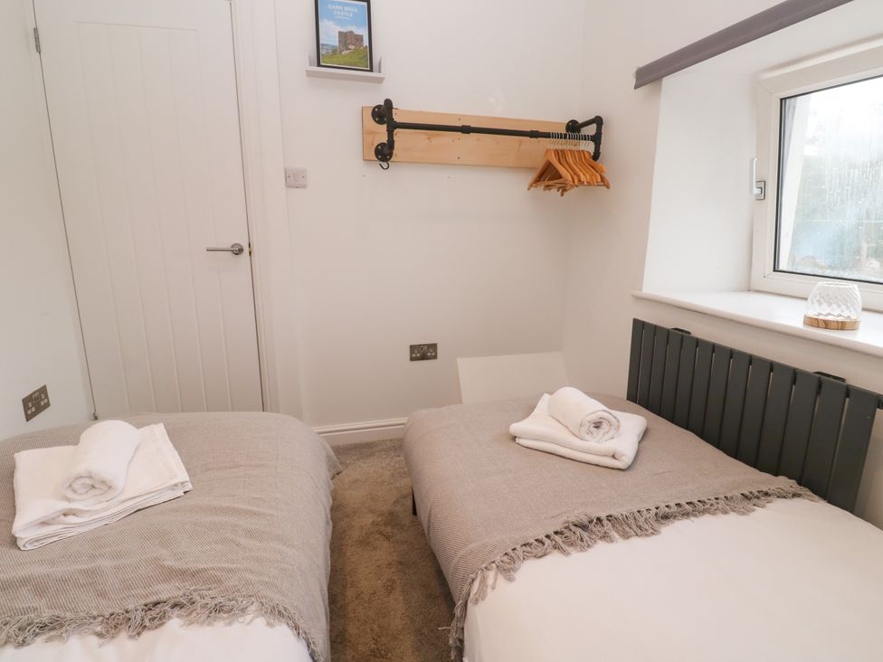 A bedroom with two beds and a window at The Lookout in Redruth