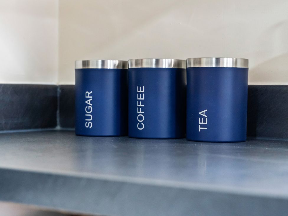 Three containers labeled sugar, coffee, and tea on a kitchen shelf at Flat 34 Herbert James Close in Birmingham
