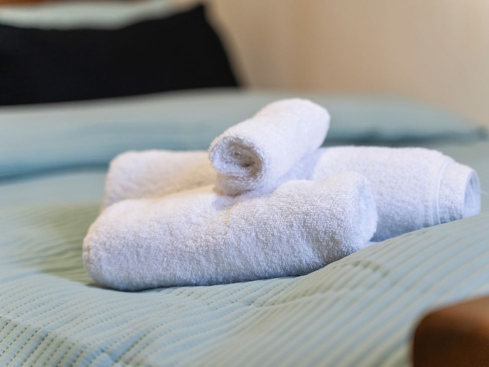A stack of towels on a bed at Flat 34 Herbert James Close in Birmingham