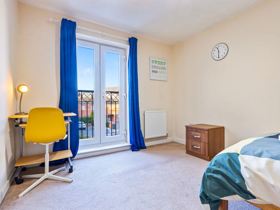 A bedroom with a desk and yellow chair at Flat 34 Herbert James Close in Birmingham