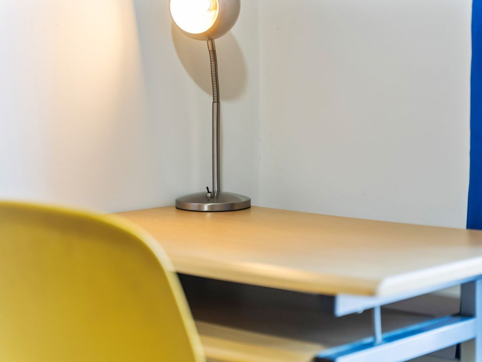 A desk with a lamp and a chair at Flat 34 Herbert James Close in Birmingham