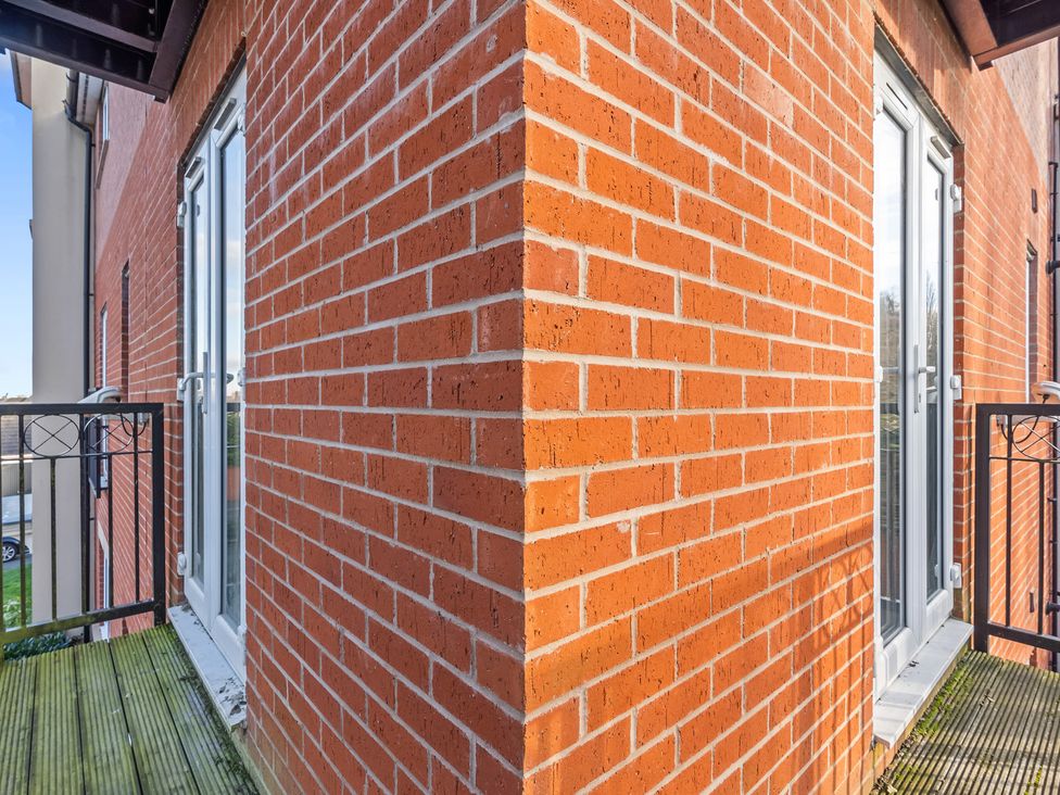 An outdoor balcony with brick walls and glass doors at Flat 34 Herbert James Close Birmingham