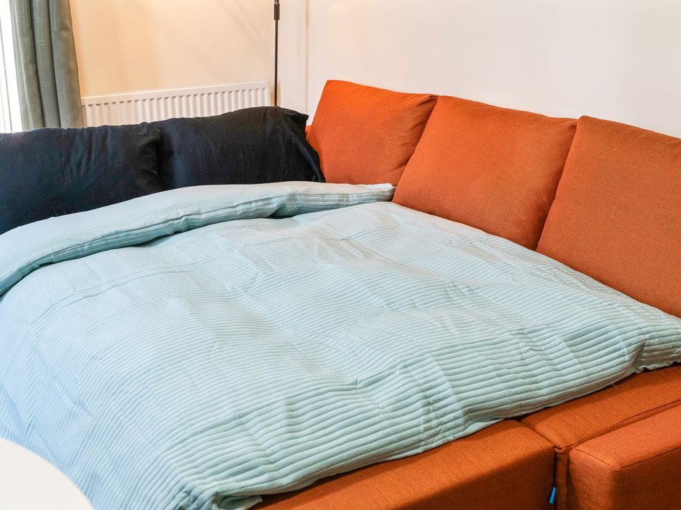 A sofa with cushions and a blanket at Flat 34 Herbert James Close in Birmingham