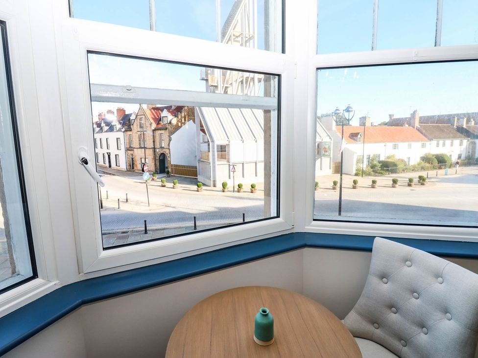 A dining area with a table and chair overlooking a street at Bishops Quarter - Barrington in Bishop Auckland