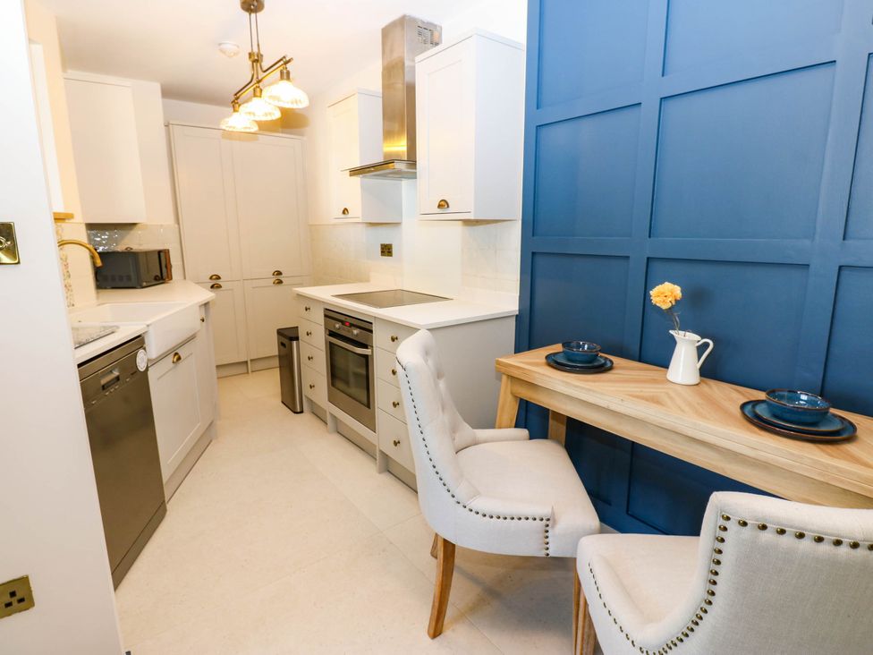 A kitchen with appliances and dining table at Bishops Quarter - Barrington in Bishop Auckland