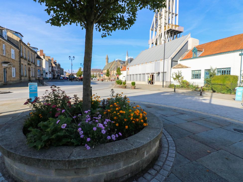 A street view with flowers and buildings at Bishops Quarter - Barrington in Bishop Auckland
