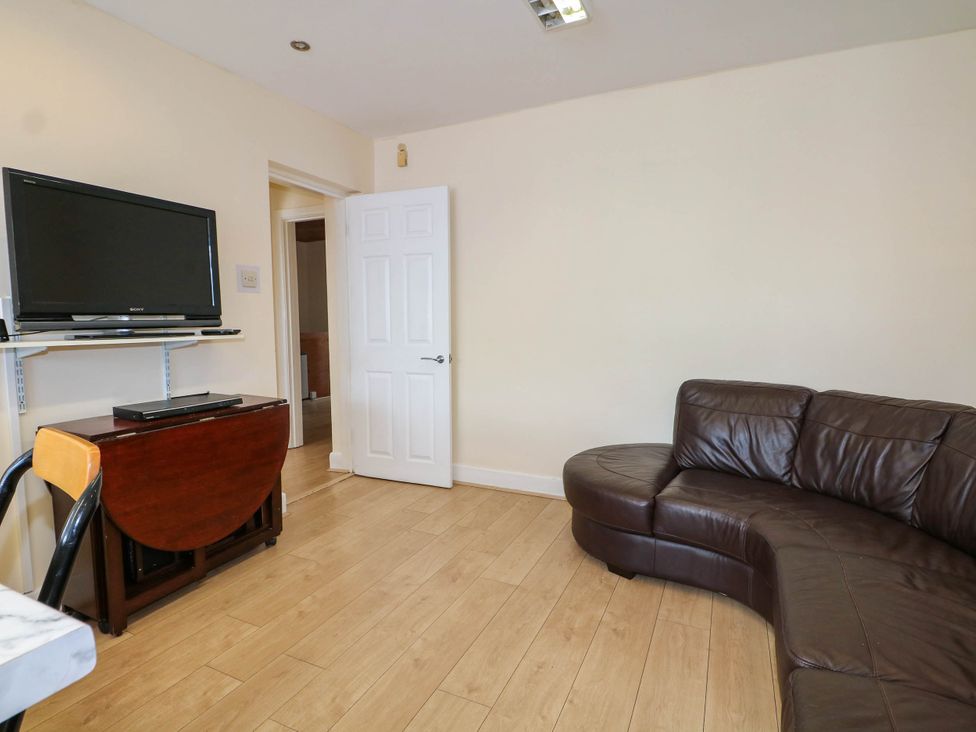 A living room with a television and sofa at 90 A Station Road New Milton