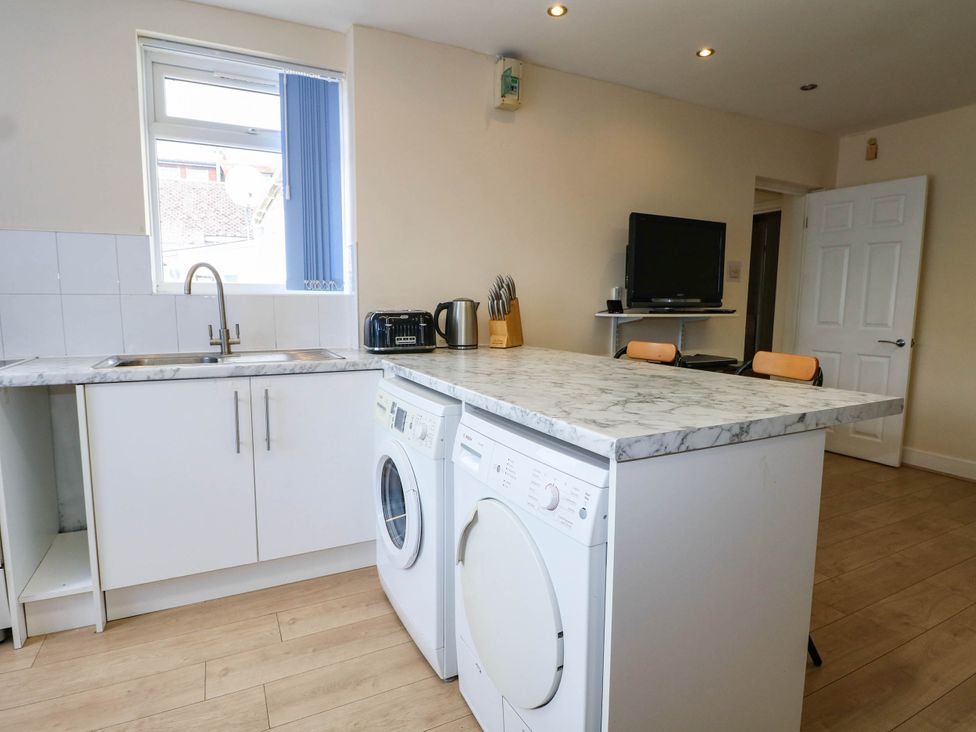 A kitchen with a sink and appliances at 90 A Station Road New Milton