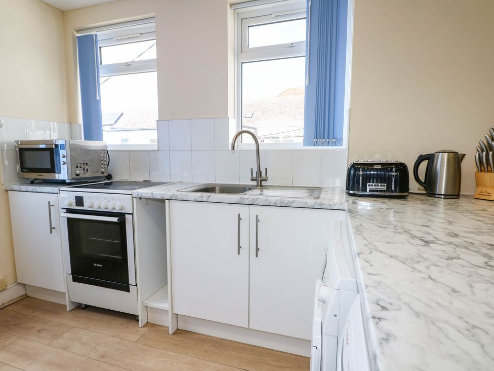 A kitchen with appliances and a sink at 90 A Station Road in New Milton