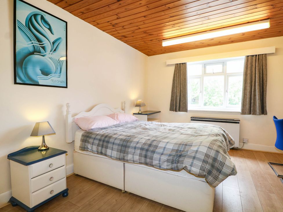 A bedroom with a bed and a bedside table at 90 A Station Road in New Milton