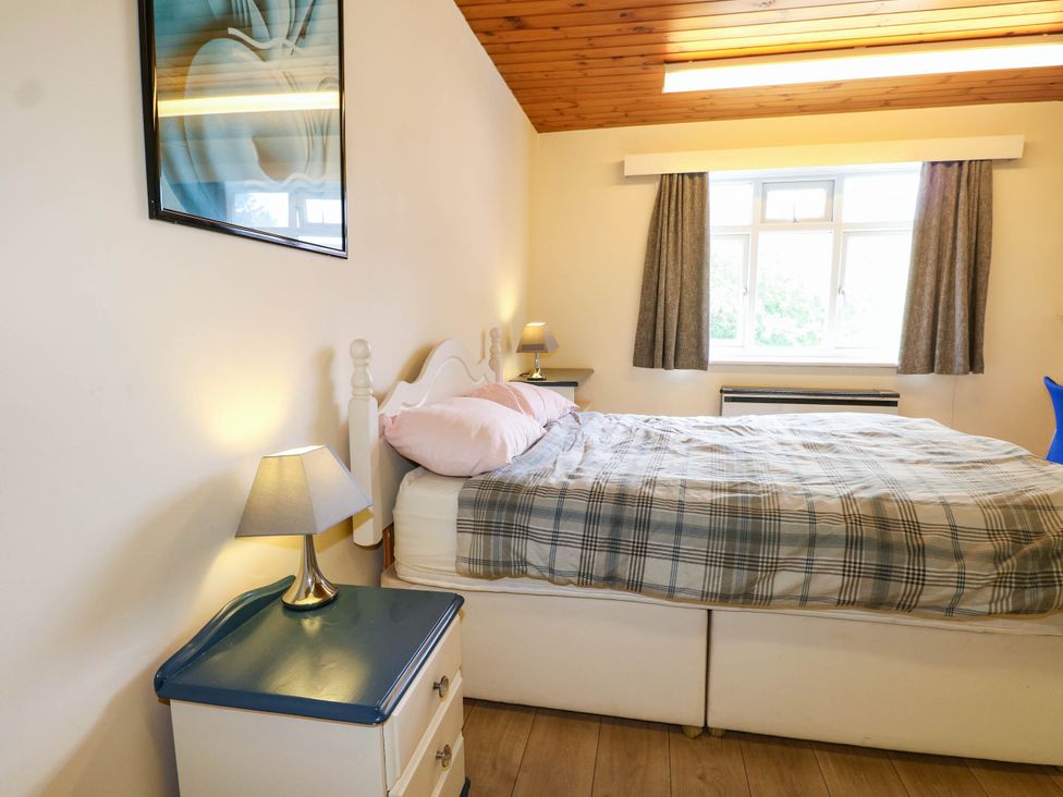 A bedroom with a bed and nightstand at 90 A Station Road in New Milton