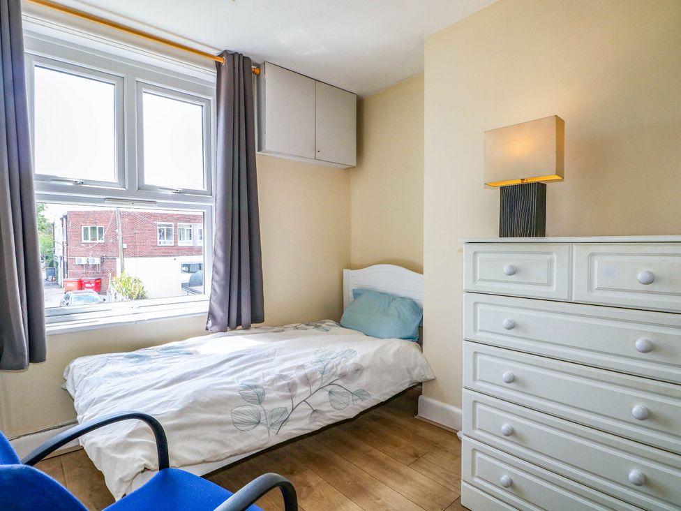 A bedroom with a bed, lamp, dresser, and window at 90 A Station Road in New Milton