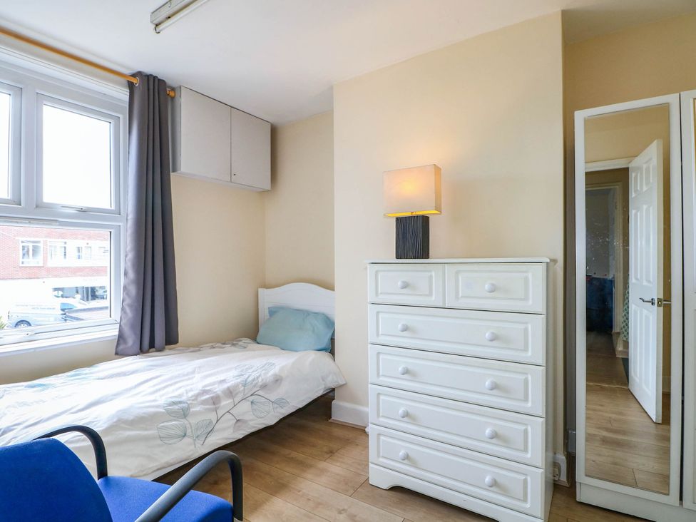 A bedroom with a bed and dresser at 90 A Station Road in New Milton