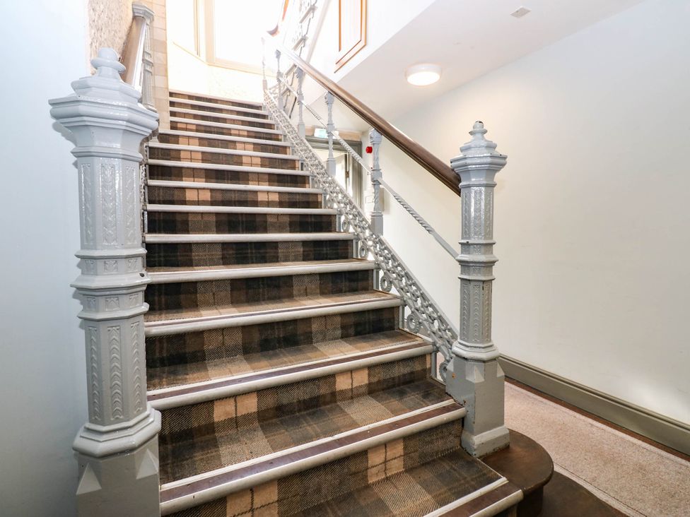 A staircase with a carpet and railing at Bishops Quarter - Flambard in Bishop Auckland