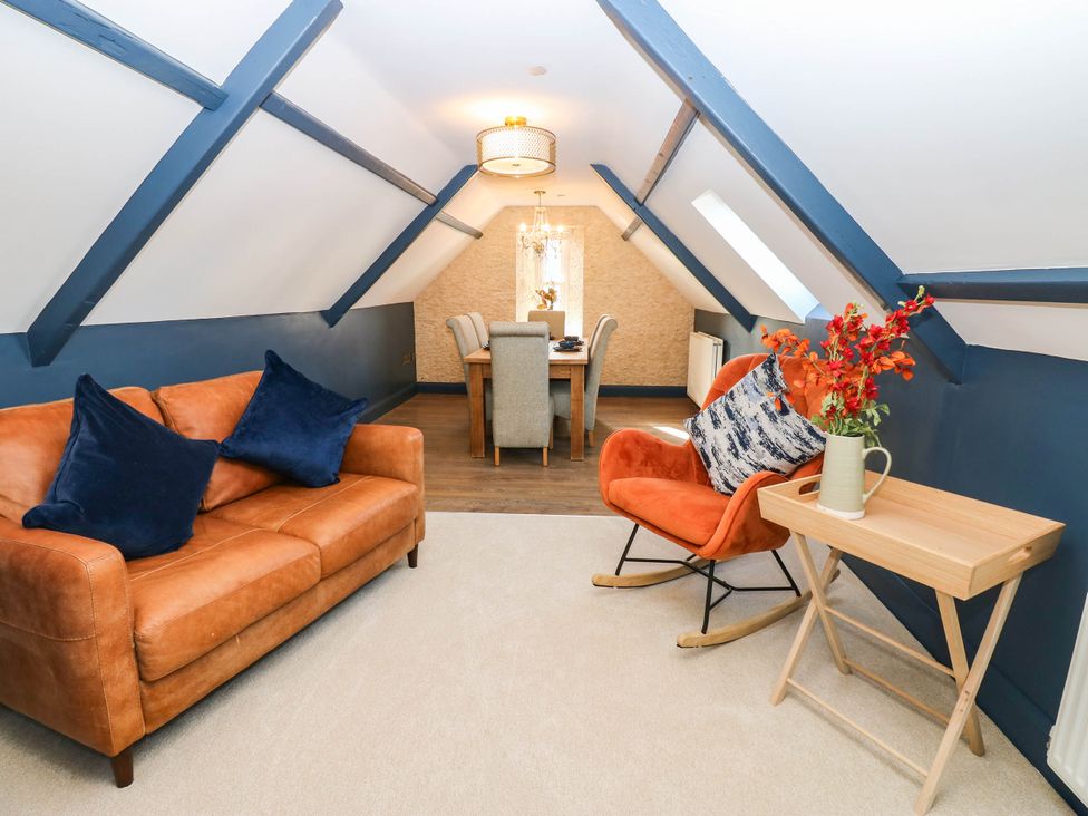 A living room with a sofa and dining area at Bishops Quarter - Flambard, Bishop Auckland