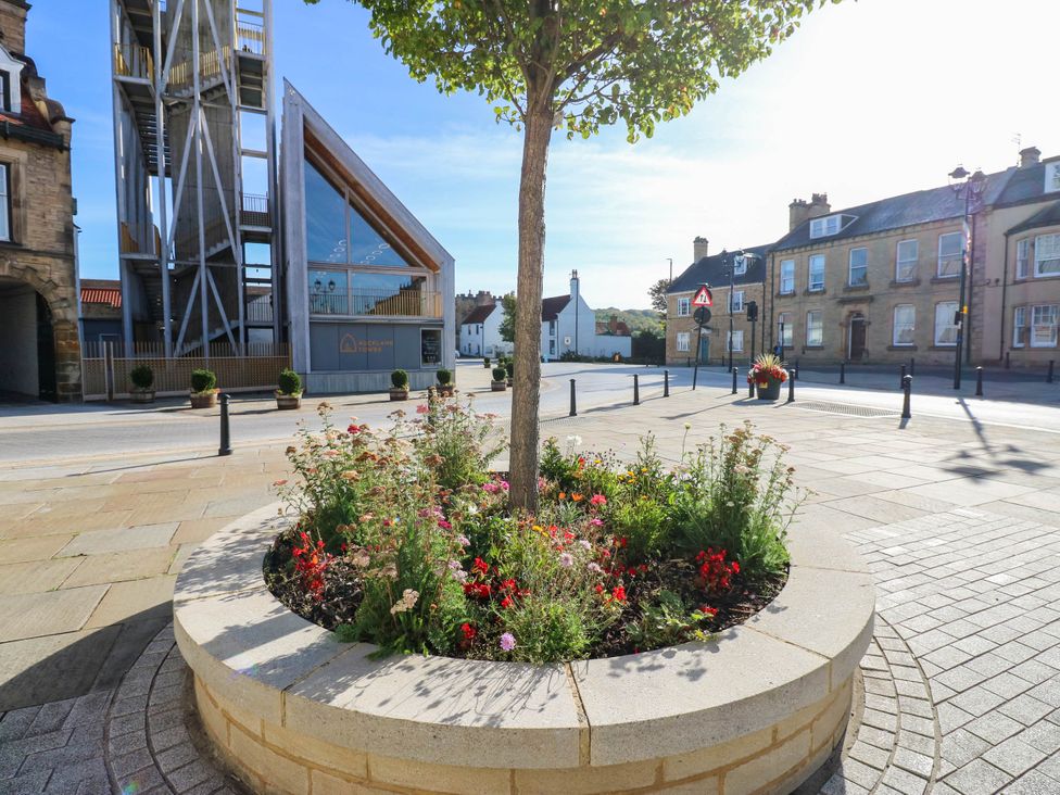 An outdoor area with a tree and flowers in a planter at Bishops Quarter - Flambard in Bishop Auckland