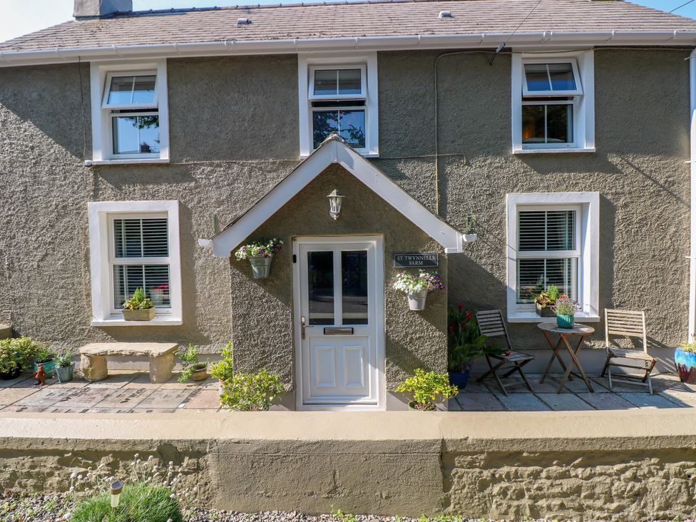 A house exterior with a door and seating area at St.Twynells Farm in Pembroke