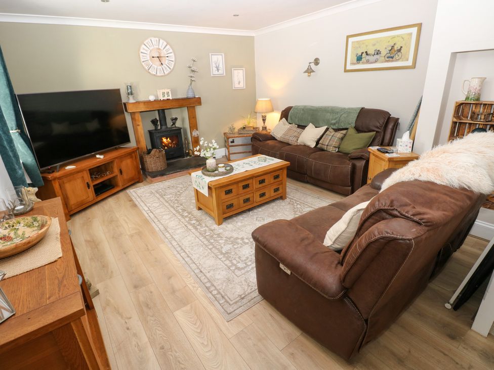 A living room with a fireplace and sofas at St.Twynells Farm in Pembroke