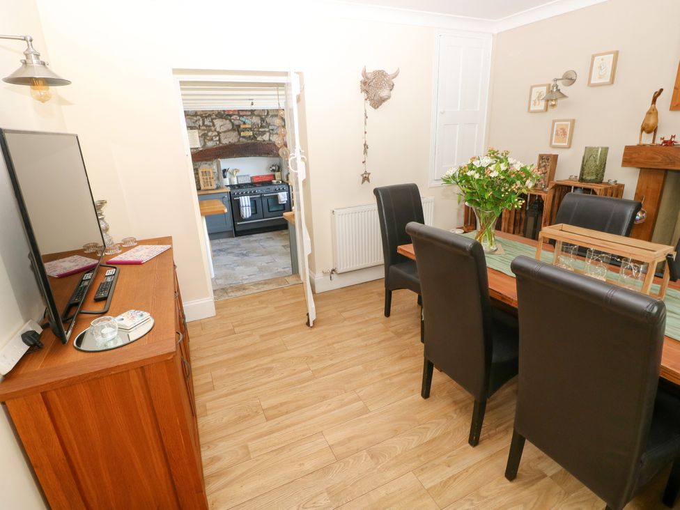 A dining room with a table and chairs at St.Twynells Farm in Pembroke