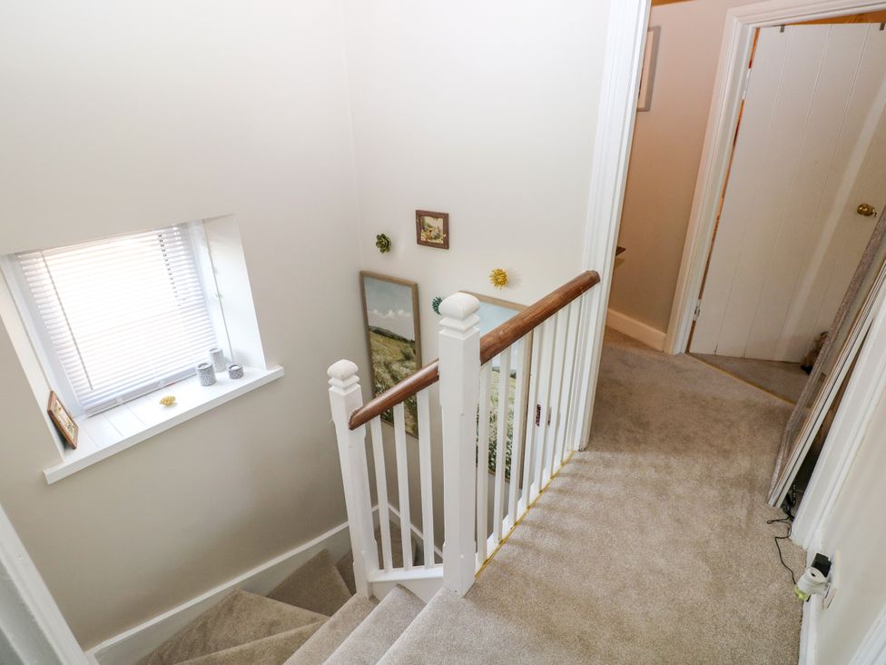 A staircase leading down with wall decorations at St.Twynells Farm in Pembroke