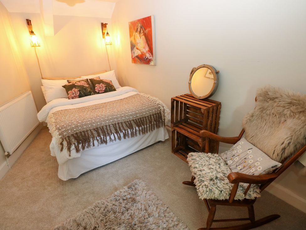 A bedroom with a bed and a rocking chair at St.Twynells Farm in Pembroke