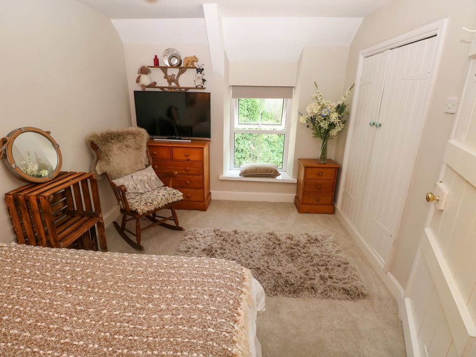 A bedroom with a bed and television at St.Twynells Farm in Pembroke