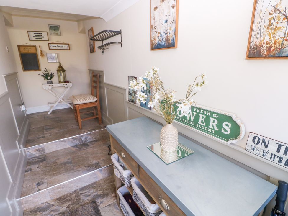 A hallway with a table and chair at St.Twynells Farm in Pembroke