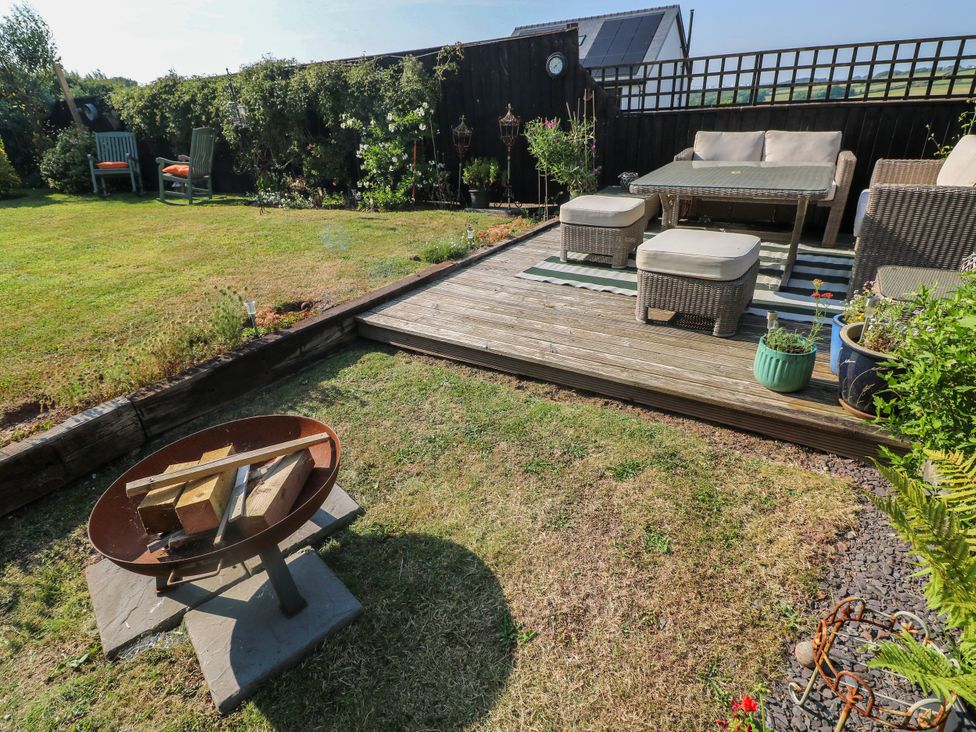 A garden with outdoor seating and a fire pit at St.Twynells Farm in Pembroke