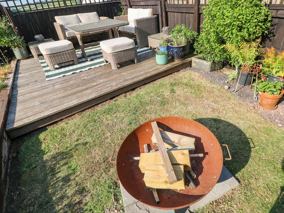 A garden with seating area and fire pit at St.Twynells Farm in Pembroke