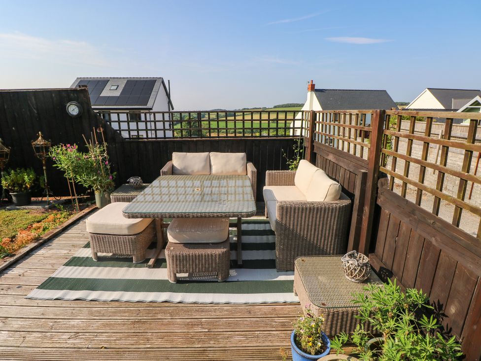 An outdoor seating area with a table and chairs at St.Twynells Farm Pembroke