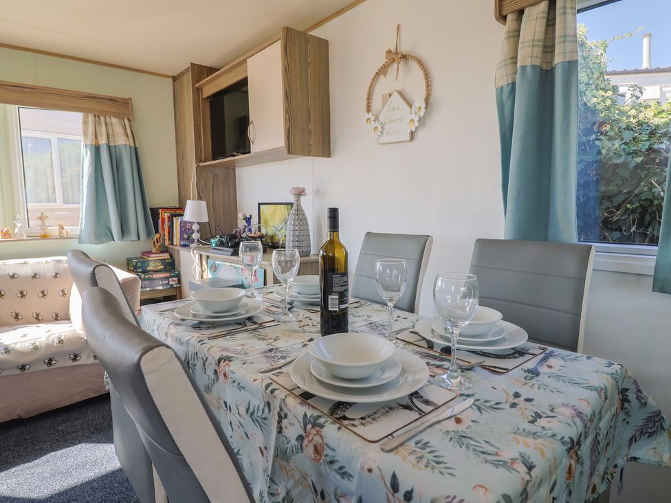 A dining room with a table set for dinner at Beech Walk 3 Sandy Bay, Exmouth