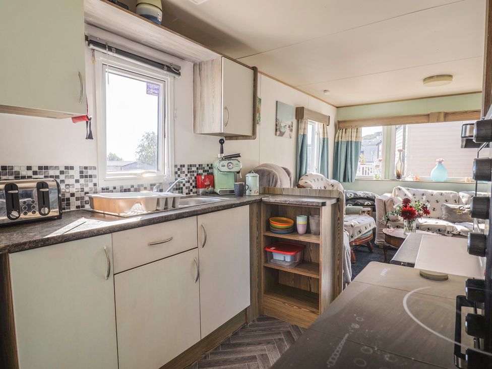 A kitchen with cabinets and appliances at Beech Walk 3 Sandy Bay Exmouth
